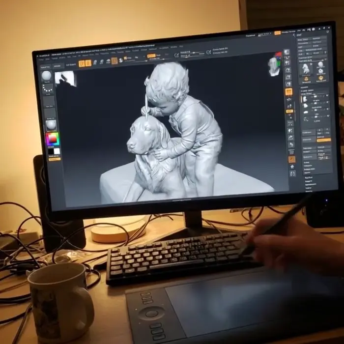 The model being sculpted on screen, a stylus on the tablet in front of it